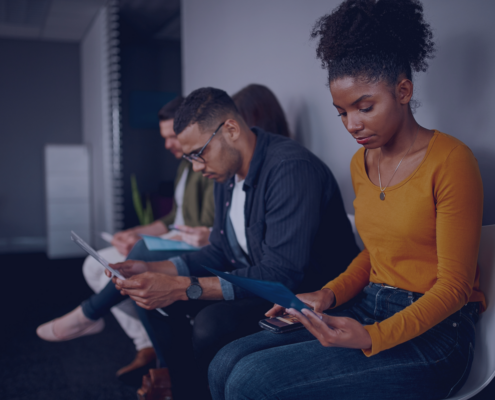 A group of South African jobseekers focused on their materials while waiting for interviews, exemplifying the proactive preparation strategies outlined in Measured Ability's guide for seasonal job applications