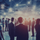 Group of finance professionals networking in a corporate event, connecting and exchanging information, illustrating the essential networking skills for job seekers in the finance sector."