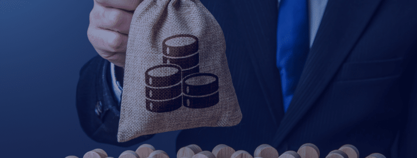 A concept image depicting a hand holding a money bag with coin stacks symbolizing budget allocation over a group of wooden figures representing staffing in startups