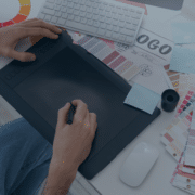 Graphic designer working with a drawing tablet and color samples, depicting the creative recruitment process in design industries.