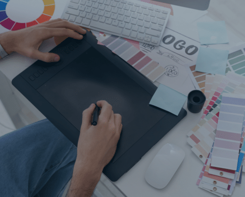 Graphic designer working with a drawing tablet and color samples, depicting the creative recruitment process in design industries.