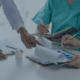 Healthcare professionals discussing nursing staff recruitment strategies over documents and charts, representing recruitment agencies' role in healthcare.