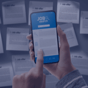 Hand holding a smartphone with a job search application on the screen amidst scattered job offer papers, representing online job-seeking strategies in South Africa
