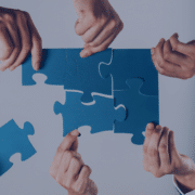 Hands assembling puzzle pieces, symbolizing the integration of recruitment agencies into internal hiring processes for smooth collaboration.