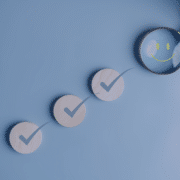 Magnifying glass highlighting a smiley face among check marks, representing signs of a good employer